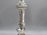 pair of silver candlesticks with ornate designs on each of them