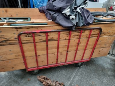 a wooden cart with a baseball glove and a bag on top of it