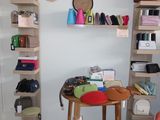 a room with a table, shelves, and bags on the wall