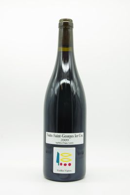 the bottle of wine is sitting on a white surface