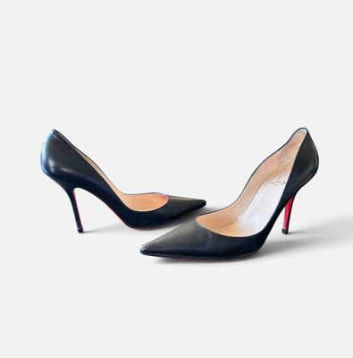 une paire de chaussures noires à talons hauts sur une surface blanche