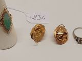 trois bagues en or et une bague sertie d'une pierre verte