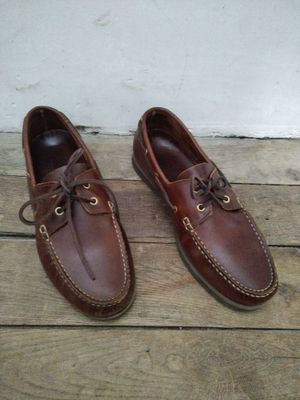 chaussures bateau en cuir marron pour homme, à lacets, posées sur un parquet