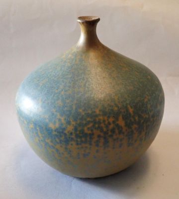 a blue and brown vase sitting on a white surface