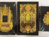 trois couvertures de livres noires et dorées ornées de motifs élaborés