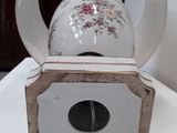 a white tea pot on a wooden stand on a table