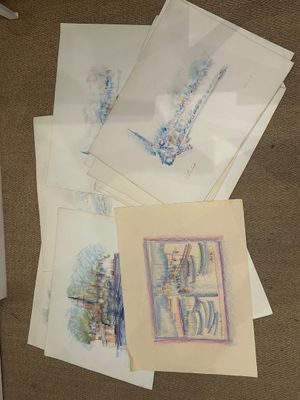 beaucoup de dessins par terre, à côté d'un ordinateur portable