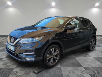 un SUV Nissan noir garé sur un sol à damier dans un garage