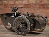 a motorcycle with a side car parked in front of a brick wall