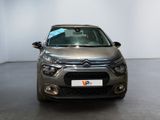 the front of a silver car is parked in a white room