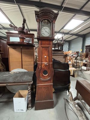 une grande horloge de parquet trônant au milieu d'une pièce