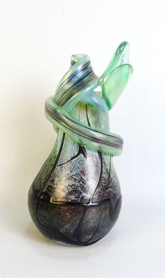 a glass vase with a ring around it on a white surface