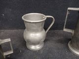 two silver vases sitting next to each other on a table