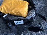 un sac noir contenant un sac jaune, posé par terre