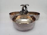 a silver bowl with a fish on top of it