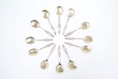 des cuillères en argent disposées en cercle sur une surface blanche