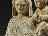 an old statue of a woman holding a baby and wearing a crown