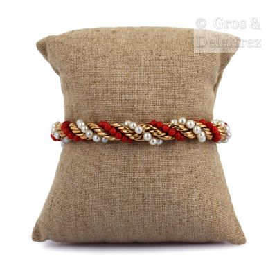 a close up of a pillow on a pillow with a bracelet on it