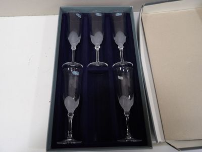 quatre verres à vin vides dans une boîte posée sur une table