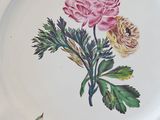 a white plate with a pink flower painted on it