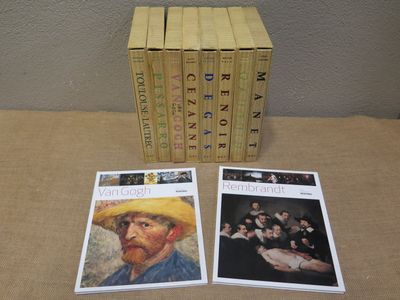 four books are sitting on a table next to a box of cards