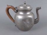 silver teapot with wooden handle on grey background with grey background