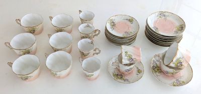 un grand nombre de tasses et de soucoupes sur une table