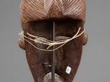 an old wooden mask with a rope around it ' s face