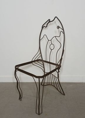 a metal chair that is sitting in the middle of a room