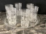 six glasses sitting on a glass tray on a table