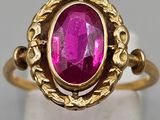 a close up of a gold ring with a pink stone in it