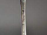 an old silver spoon with a bird on it sitting on top of a table