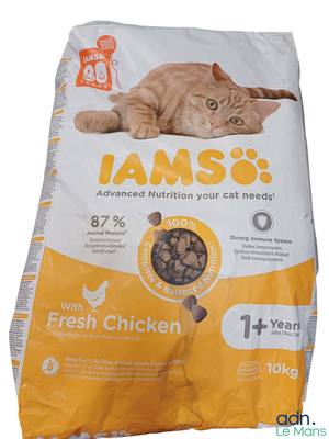 a cat laying on top of a bag of food