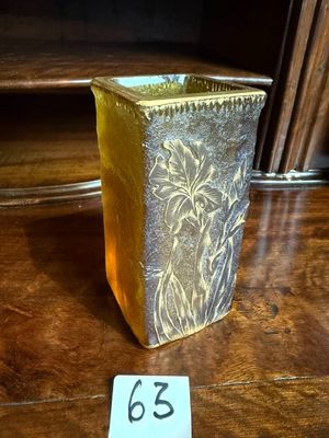 a gold vase sitting on a wooden table with a price tag on it