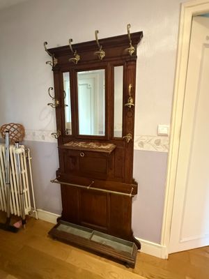 a wooden cabinet with a mirror and a radiator in the corner