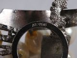 a close up of a silver ring with pearls on it