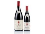 two bottles of red wine sitting next to each other on a white surface