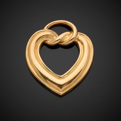 a gold heart pendant with a knot in the middle