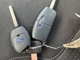 two car keys sitting on the seat of a car