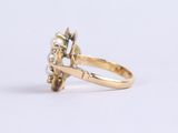 a close up of a gold ring with a diamond and a pearl