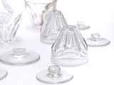 several clear glass vases are arranged on a white surface