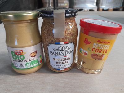 three jars of peanut butter and a jar of nut butter on the table