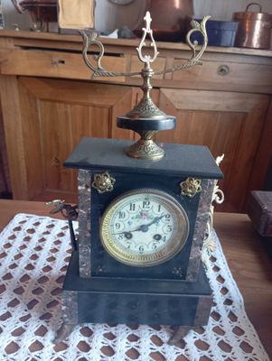 une horloge posée sur une table sur laquelle se trouve une bougie