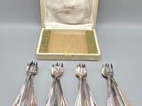 six silver spoons in a box with a case on a table