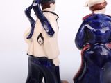 two figurines of a man and a woman standing next to each other