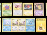 Plusieurs cartes Pokémon sont alignées sur une surface noire