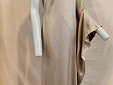une photo d'un mannequin portant une robe beige, posé sur un socle