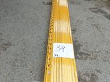 un long banc en bois sur lequel est posée une pancarte, au milieu d'un entrepôt