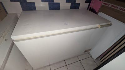 a white refrigerator in a small kitchen with a blue and white checkered wall
