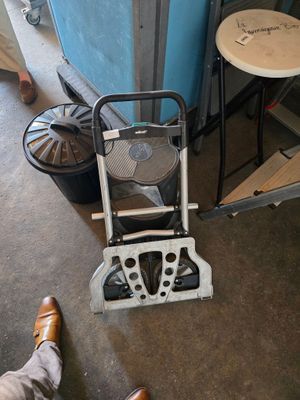 une personne debout à côté d'une chaise sur laquelle est posé un ventilateur